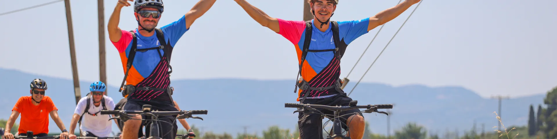 Bike Guides riding MTB's holding hands and smiling